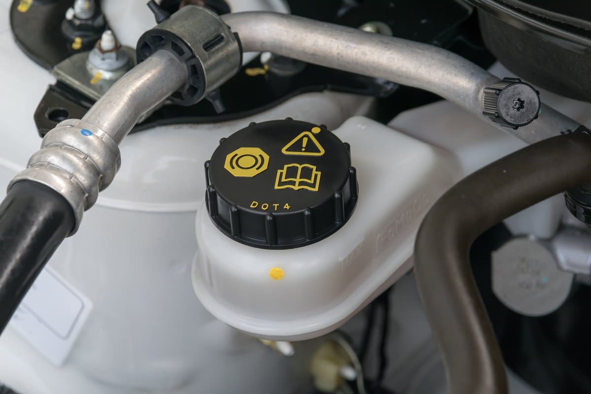 Brake fluid reservoir with a DOT 4 cap in an engine bay