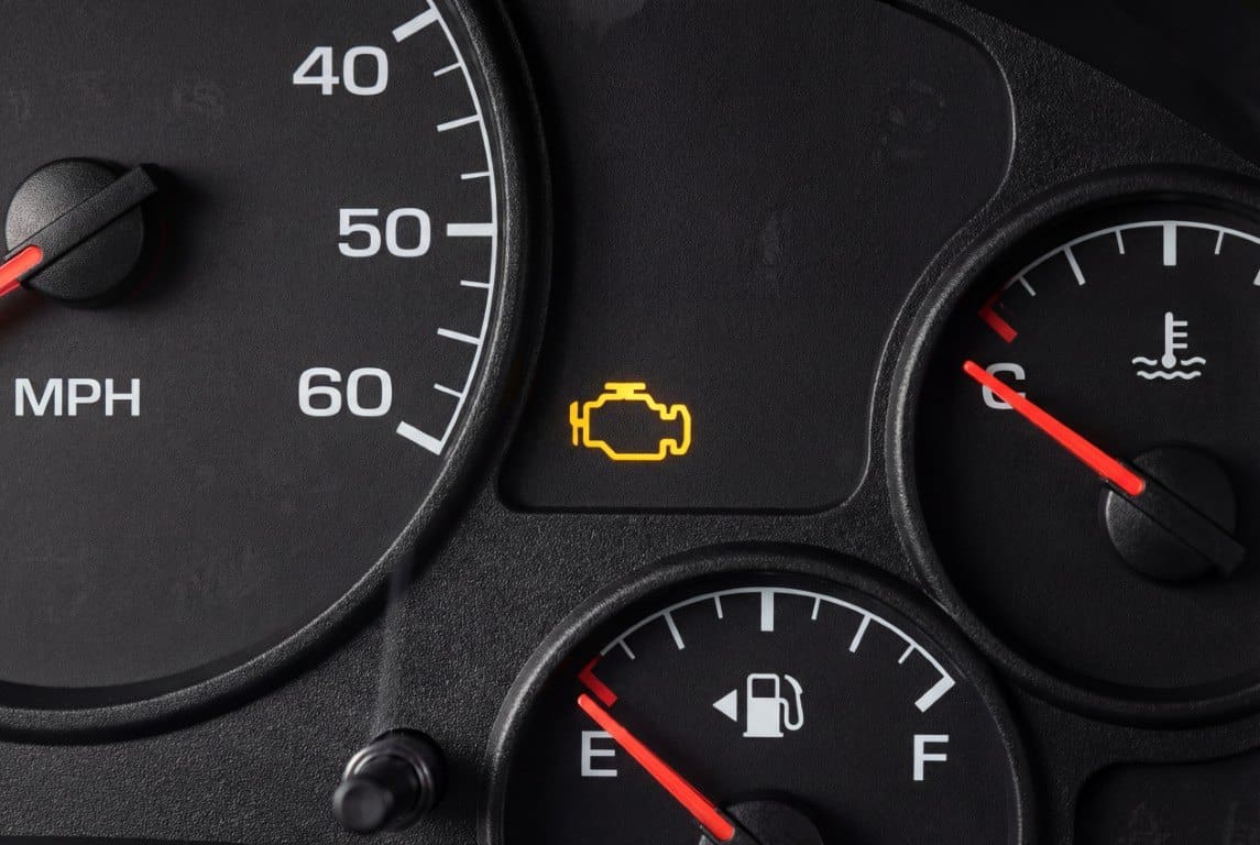 Amber check engine warning light lit on a vehicle instrument cluster