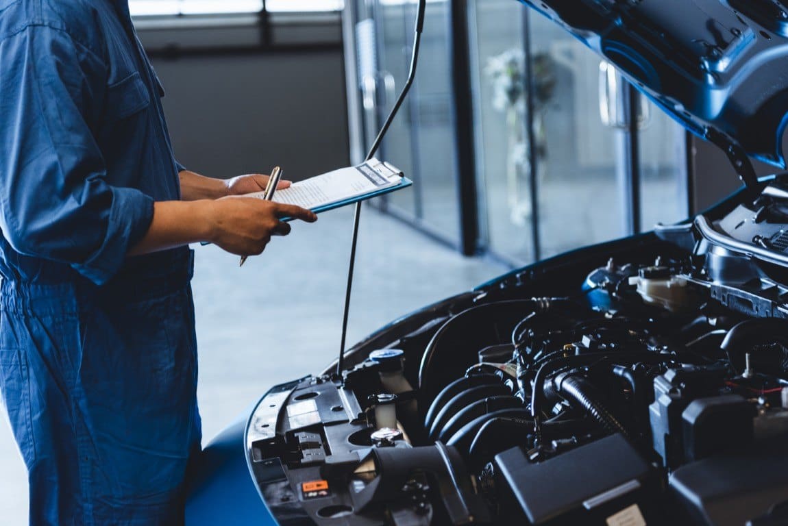 Technician with an inspection clipboard in a repair shop bay